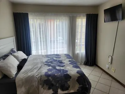 a bedroom with a bed and a television in it at Executive Harmonic Studio in Midrand