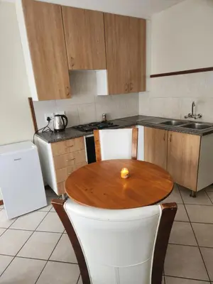 a kitchen with a wooden table and a sink at Executive Harmonic Studio in Midrand