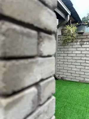 a brick wall with a green lawn behind it at Sherotha Homestay in Louis Trichardt