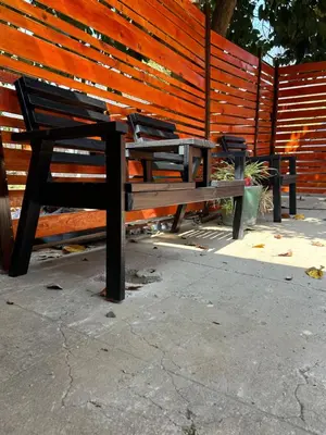 two benches sitting in front of a wooden fence at Sherotha Homestay in Louis Trichardt