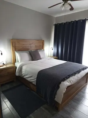a bedroom with a large bed with black curtains at Hantam Suites in Centurion