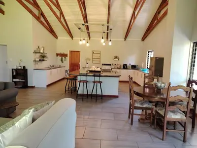 a kitchen and living room with a table and chairs at The Goat House Farmstay in Nelspruit
