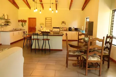 a kitchen and dining room with a table and chairs at The Goat House Farmstay in Nelspruit