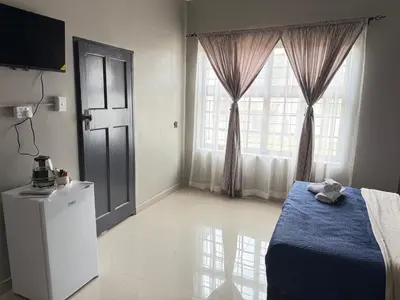 a bedroom with a blue bed and a window at Home Away Nest B&B in Witbank