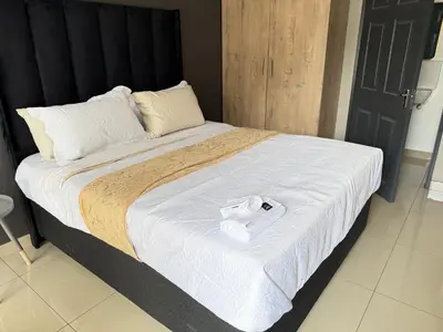 a large bed with a white towel on it at Home Away Nest B&B in Witbank