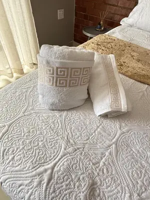 a white bed with two pillows on top of it at Home Away Nest B&B in Witbank