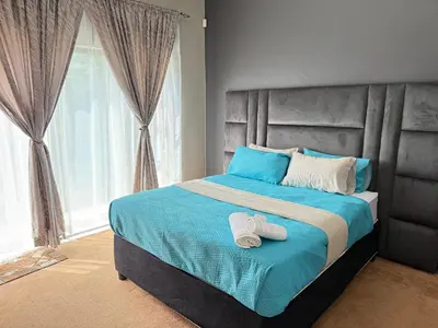 a bedroom with a bed with two towels on it at Home Away Nest B&B in Witbank
