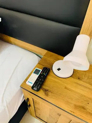 a side table with a remote control and a lamp at AA Nkhumeleni Guesthouse and Accomodation in Thohoyandou
