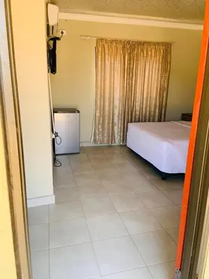 a bedroom with a bed and a tiled floor at AA Nkhumeleni Guesthouse and Accomodation in Thohoyandou