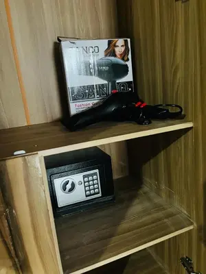 a book and a clock on a shelf with a tv at AA Nkhumeleni Guesthouse and Accomodation in Thohoyandou