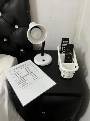 a black table with a lamp and a remote control at AA Nkhumeleni Guesthouse and Accomodation in Thohoyandou