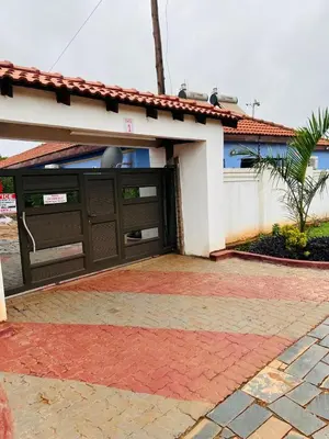 a house with a garage with a red brick driveway at AA Nkhumeleni Guesthouse and Accomodation in Thohoyandou
