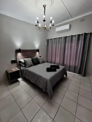 a bedroom with a bed and a chandelier at 14a on Middle Way in Tzaneen