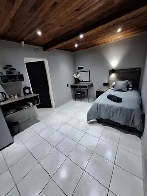 a large bedroom with a bed and a desk at 14a on Middle Way in Tzaneen