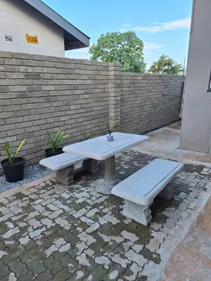 a picnic table and two benches in front of a brick wall at 14a on Middle Way in Tzaneen