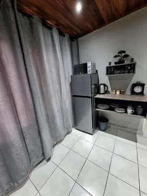 a kitchen with a small refrigerator and a kitchen with at 14a on Middle Way in Tzaneen