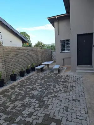 a patio with two benches in front of a building at 14a on Middle Way in Tzaneen
