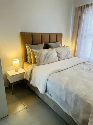 a bedroom with a large bed with a lamp on a table at Calm & Cozy Apartment 2 in Pretoria