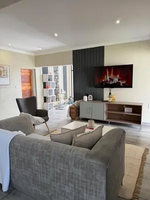 a living room with a couch and a tv at The Prestige Home in Middelburg