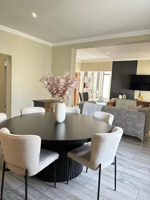 a dining room with a black table and chairs at The Prestige Home in Middelburg