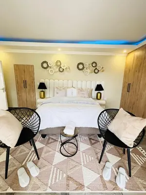 a bedroom with a large bed and two chairs at The Prestige Home in Middelburg