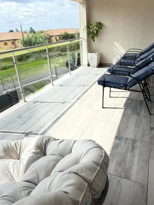a balcony with two chairs and a couch on a deck at The Prestige Home in Middelburg
