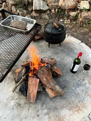 a pot and a fire next to a grill with a pot and a fire at Ingwenya View in Marloth Park