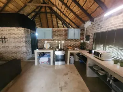 a kitchen with a counter and a brick wall at Lazy River Retreat in Pretoria