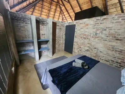 a room with a bed and a brick wall at Lazy River Retreat in Pretoria