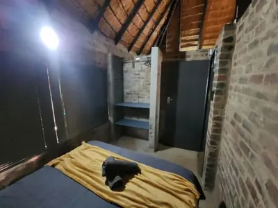 a room with a bed and a brick wall at Lazy River Retreat in Pretoria