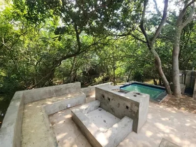 a swimming pool with a concrete bench and a table at Lazy River Retreat in Pretoria