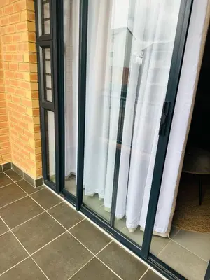 a group of glass windows with white curtains at Calm & Cozy Apartment 3 in Pretoria