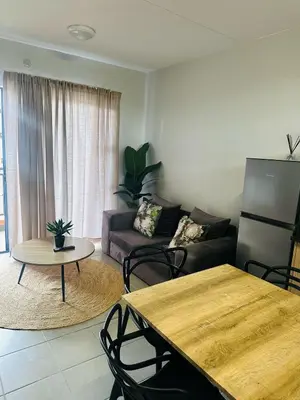 a living room with a couch and a table at Calm & Cozy Apartment 3 in Pretoria