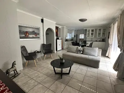 a living room with a couch and a table at AfriSky guest house in Kempton Park