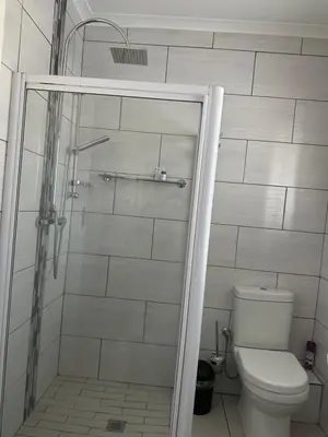 a bathroom with a shower and a toilet at AfriSky guest house in Kempton Park