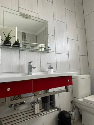 a bathroom with a sink and a mirror at AfriSky guest house in Kempton Park