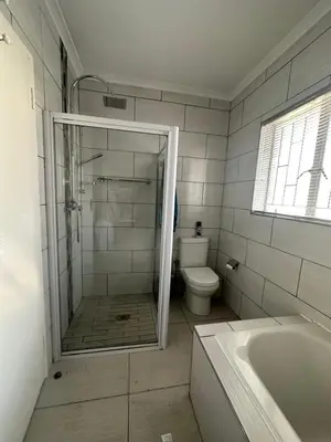 a bathroom with a shower and a toilet and a tub at AfriSky guest house in Kempton Park