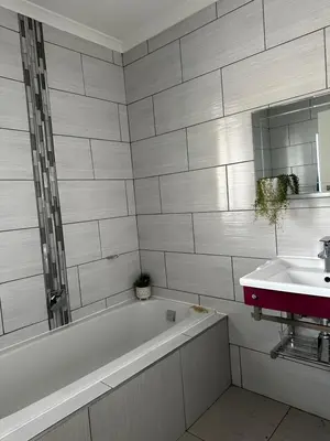 a bathroom with a bath tub and a sink at AfriSky guest house in Kempton Park