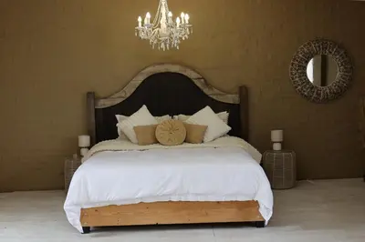 a bedroom with a large white bed with a chandelier at Shiloh Bush Cottage in Nelspruit