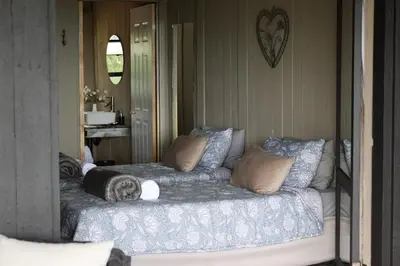 a bed with pillows on it in a room at Shiloh Bush Cottage in Nelspruit