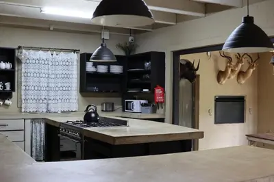 a kitchen with black cabinets and a counter top at Shiloh Bush Cottage in Nelspruit