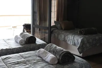 two beds with pillows on them in a bedroom at Shiloh Bush Cottage in Nelspruit