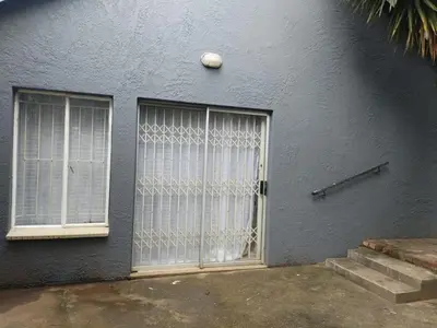 a gray building with a door and two windows at Wildflower Haven in Midrand