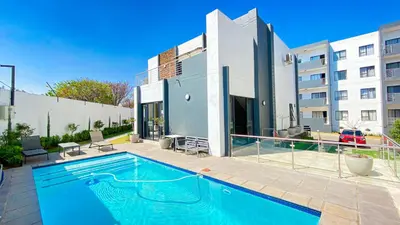 a swimming pool in front of a building at BinBins Suite Haven in Midrand