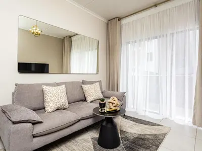 a living room with a couch and a table at BinBins Suite Haven in Midrand