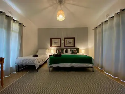 a bedroom with two beds and a chandelier at Harmonie Hills in Sukani