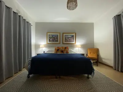 a bedroom with a blue bed with two lamps and a chair at Harmonie Hills in Sukani