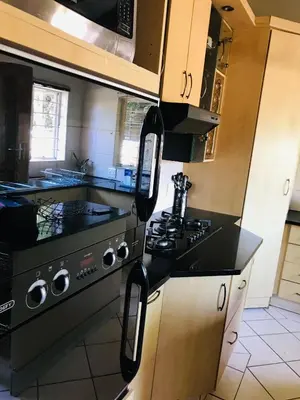 a kitchen with a black stove top oven at The Cosy Den in Centurion