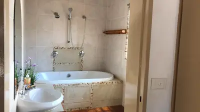 a bathroom with a tub and a sink at The Cosy Den in Centurion