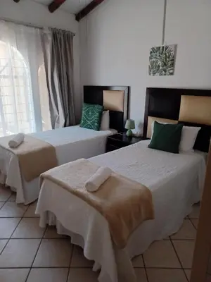 a bedroom with two beds and a window at The Cosy Den in Centurion